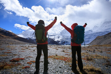 Two women hikers hiking  in winter mountains