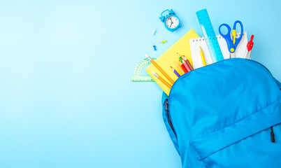 School bag. Backpack with supplies for school on blue background. Copy space for text © adragan