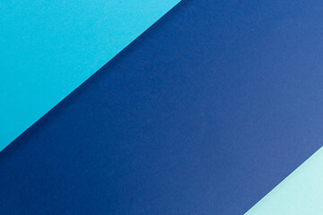 Material design blue background. Craft paper sheets are folded in different ways. A photo.