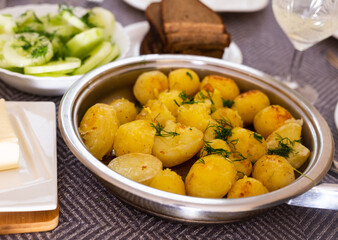 toasted young potatoes with dill in metal skillet
