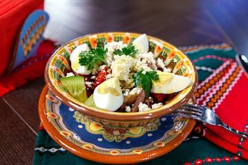 Appetizing salad with beef tongue, boiled eggs, cheese and vegetables. Bulgarian cuisine