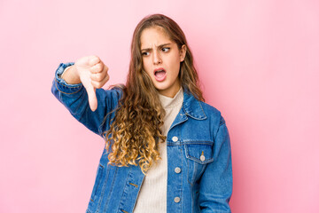 Young caucasian woman showing thumb down and expressing dislike.