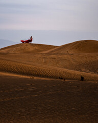 Fototapeta na wymiar Frau mit rotem Kleid in der Wüste von Abu Dhabi
