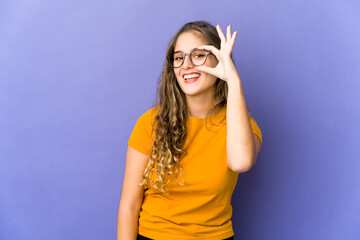 Young caucasian cute woman excited keeping ok gesture on eye.
