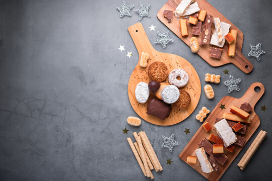 Traditional Spanish Christmas sweets turron, polvorones, mantecados with Christmas decor on grey table top, copy space