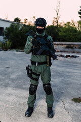 Man reenacting special unit of Croatian military police. Wearing green jumpsuit with black add-ons and assault rifle G36.