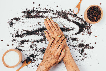Female hands apply fresh natural coffee body scrub