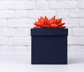 blue square cardboard box with red bow