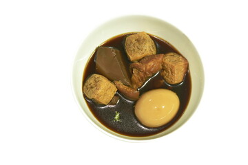 boiled egg topping  fried tofu and pork leg with blood in herb brown soup on bowl