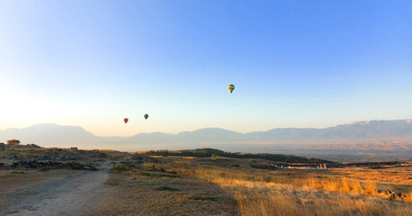 Hot air balloons in the blue sky over the valley at sunrise. High quality photo
