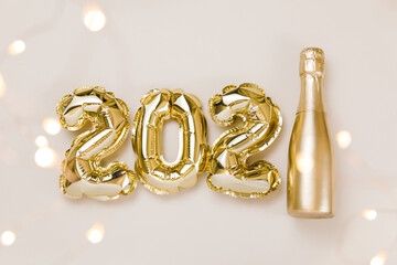 Happy New year 2021 celebration. Gold foil balloons numeral 2021, party decoration on beige and Set Sail Champagne background. Flat lay, christmas creative concept