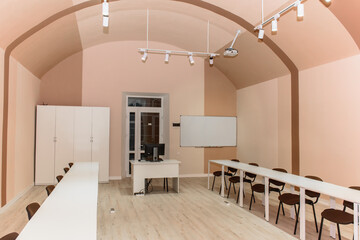 Lecture hall or school empty classroom with bright desks and chairs for learning lessons, teaching, educational concept. Selective focus
