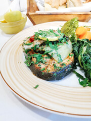 Grilled salmon served with grilled eggplants on top and mixed vegetables for side dishes for an healthy meal