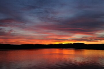 Beautiful sunset in the North. The city of Murmansk. Red setting sun against the background of mountains.