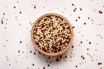 close Set of three varieties of uncooked quinoa on white background, top view