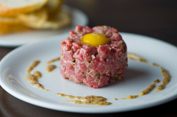 Steak tartare. Classic American restaurant or French bistro appetizer classic. Steak diced, mixed with eggs, red onions, olive oil, lemon juice, garlic and capers. Served with garlic bread.