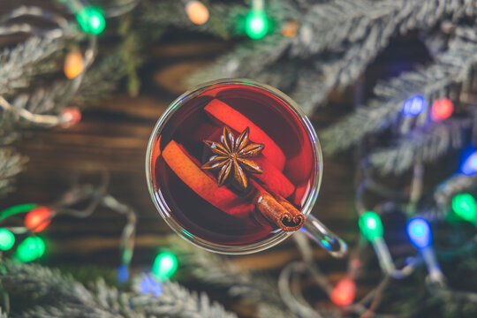 Christmas hot mulled wine in a glass with spices and citrus fruit. Mulled wine with cinnamon, anise and orange. Top view and copy space.