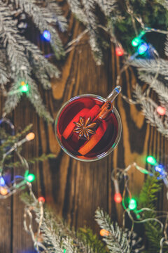 Christmas hot mulled wine in a glass with spices and citrus fruit. Mulled wine with cinnamon, anise and orange. Top view and copy space.
