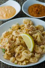 Calamari served with spicy and sweet dipping sauces. Classic American restaurant or French bistro appetizer favorite. Fresh octopus, squid and shrimp battered and deposed fried.
