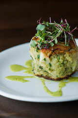 Crab cake. Crab served with spicy rémoulade sauce on top of a mixed green salad. Jumbo crab meat mixed with garlic, onions, spices & fried in butter. Classic American restaurant appetizer.