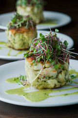Crab cake. Crab served with spicy rémoulade sauce on top of a mixed green salad. Jumbo crab meat mixed with garlic, onions, spices & fried in butter. Classic American restaurant appetizer.