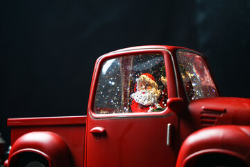 new year mockup souvenir red car with santa driving on a black background macro photo
