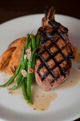 Salmon steak. Salmon grilled in olive oil, topped with almonds, scallions and Italian parsley. Served with garlic Brussel sprouts. Classic American restaurant or French bistro entree.