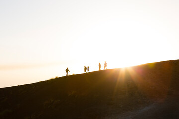 Sicily, Italy. A small group of tourists explore the rim of the Silvestri Inferiore crater near the summit of Mt Etna.