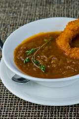 French Onion Soup. Classic traditional french restaurant bistro menu item. French onion soup, yellow onions reduced in broth topped with cheese melted and served with homemade baguettes. 