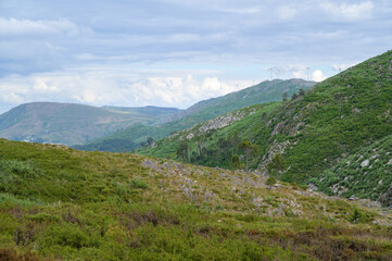 Fototapeta na wymiar Freita mountain range highland. Rocky landscape with clouds. Hills with yellow and green vegetation.