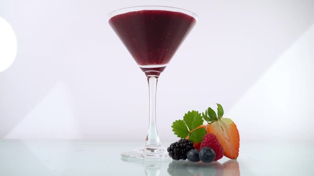 Pouring Wild Berry Margarita in a Cocktail Glass on white Background