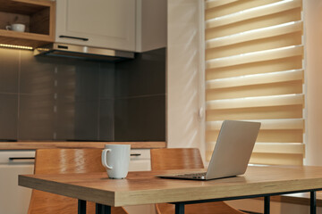 Telecommuting workspace with laptop and cup of coffee