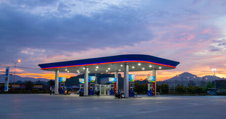 Gas station at sunrise and orange sky .
