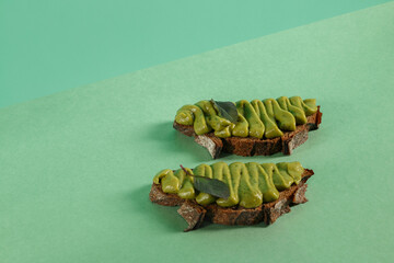Avocado pasta with green basil, garlic and coconut cream on whole grain bread