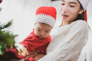 merry christmas and happy Holidays. mother held her daughter near the christmas tree and decorate the christmas tree indoors. the morning before Xmas. Portrait loving family close up.