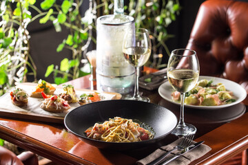crab meat tomato pasta spaghetti with glass of white wine on the table at restaurant