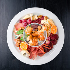 Antipasto delicatessen sliced meat, ham, salami, cheese, olives on dark table, anti-paste, Italian antipasto