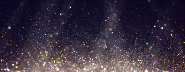 background of abstract glitter lights. silver, gold and black. de focused