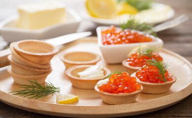 cooking tartlets with red caviar on wooden table