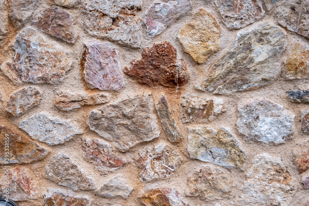 Wall mural stone wall background and texture, pink red stones built surface