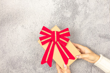 Woman's hands holding gift box on the table.- Christmas and New Year concept.