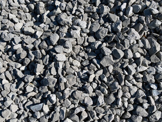 closeup grey stone pepple rocks overhead view with deep shadows and bright details as backdrop background for website architecture scenery