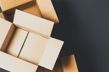 Empty open brown cardboard boxes on dark gray color background. Top view