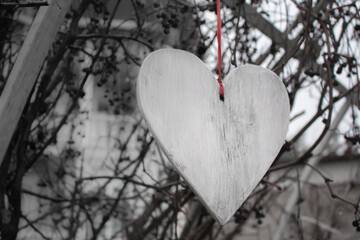 Heart with ribbon outdoor, black and white. Hanging wooden heart, monochrome. Romance and love concept. Valentines day. Outdoor wedding decoration. Handmade wooden heart. Love symbol. Unhappy love.