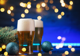 Christmas toast card, two glasses of light beer on a colored neon background with garlands and copy...