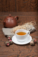 Clay Chinese teapot pot and cup of tea with Flower Chinese tea on old wooden table
