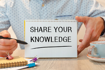 Notebook with text SHARE YOUR KNOWLEDGE near office supplies.