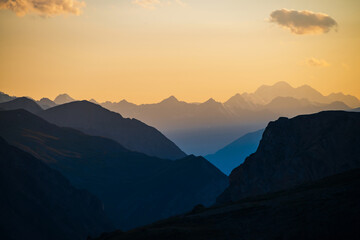 Colorful dawn landscape with beautiful blue mountains silhouettes and golden gradient sky with...