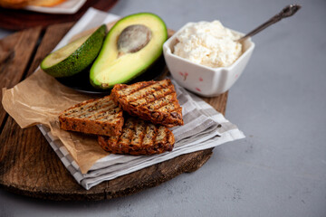 Sandwiches with soft cheese, avocado and cucumber. Breakfast is on the table. Healthy food. Toast and spread on it. Avocado sandwich stilllife. Healthy food. Toast.