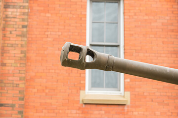 Armourd tank gun muzzle in front of red brick wall